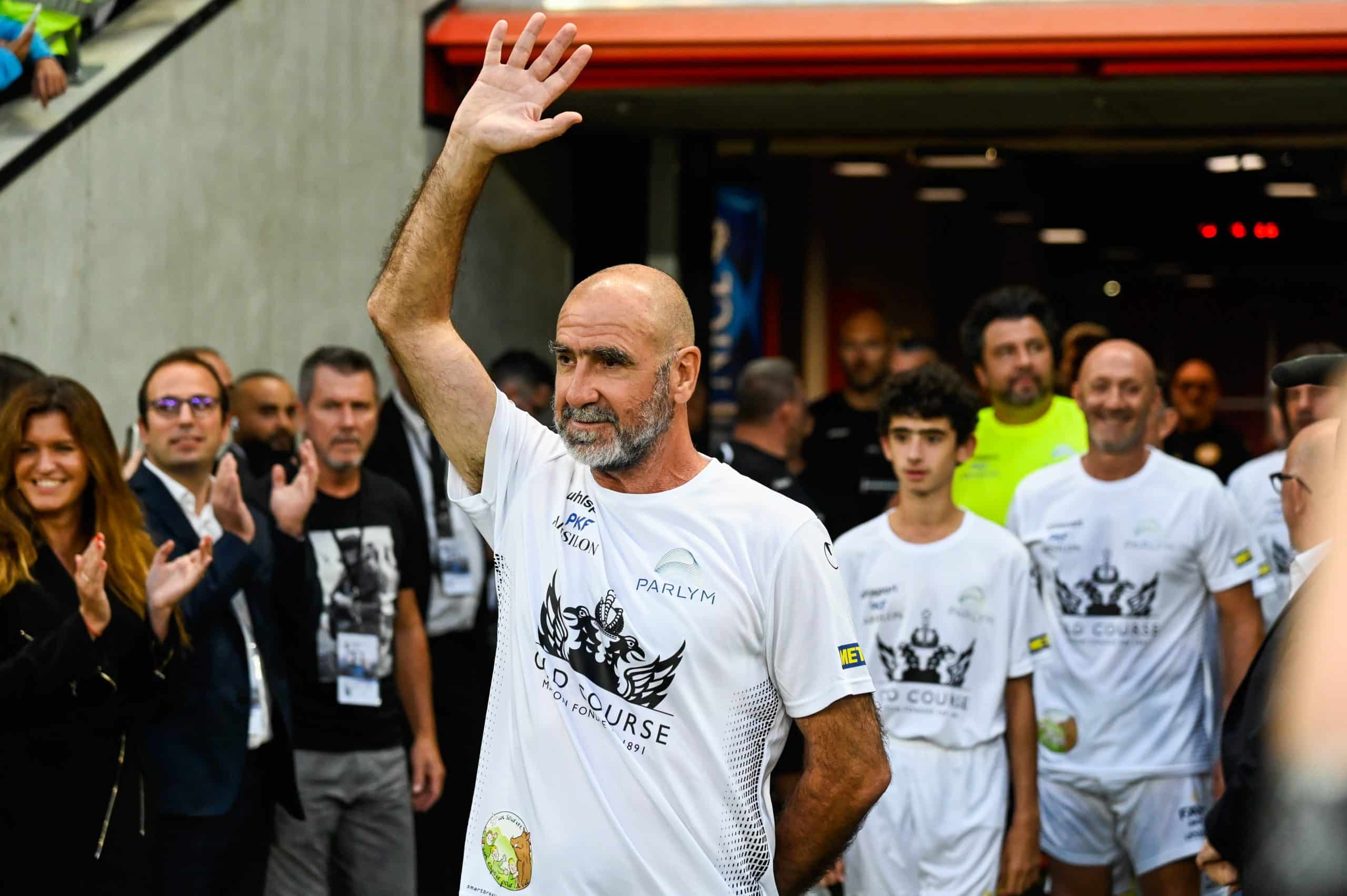 Eric Cantona saluant le public avant un match caritatif.