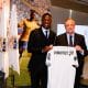 Vinicius Jr posant avec Florentino Pérez et un maillot du Real Madrid, en 2018.