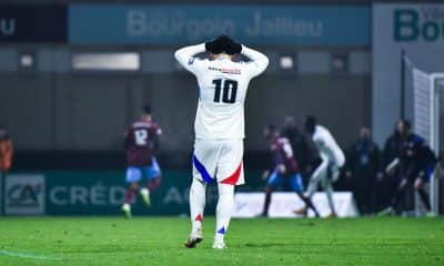 Rayan Cherki se tient la tête à deux mains après l'élimination de l'OL sur la pelouse de Bourgoin-Jallieu.