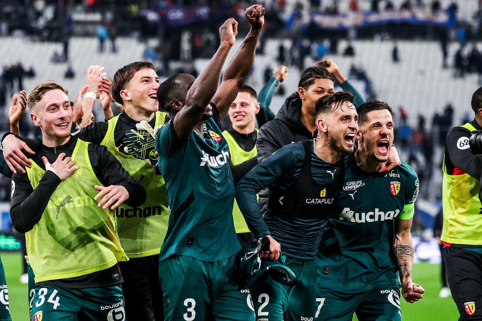 Tom Pouilly au milieu de ses partenaires du RC Lens en train de fêter la victoire à Marseille.