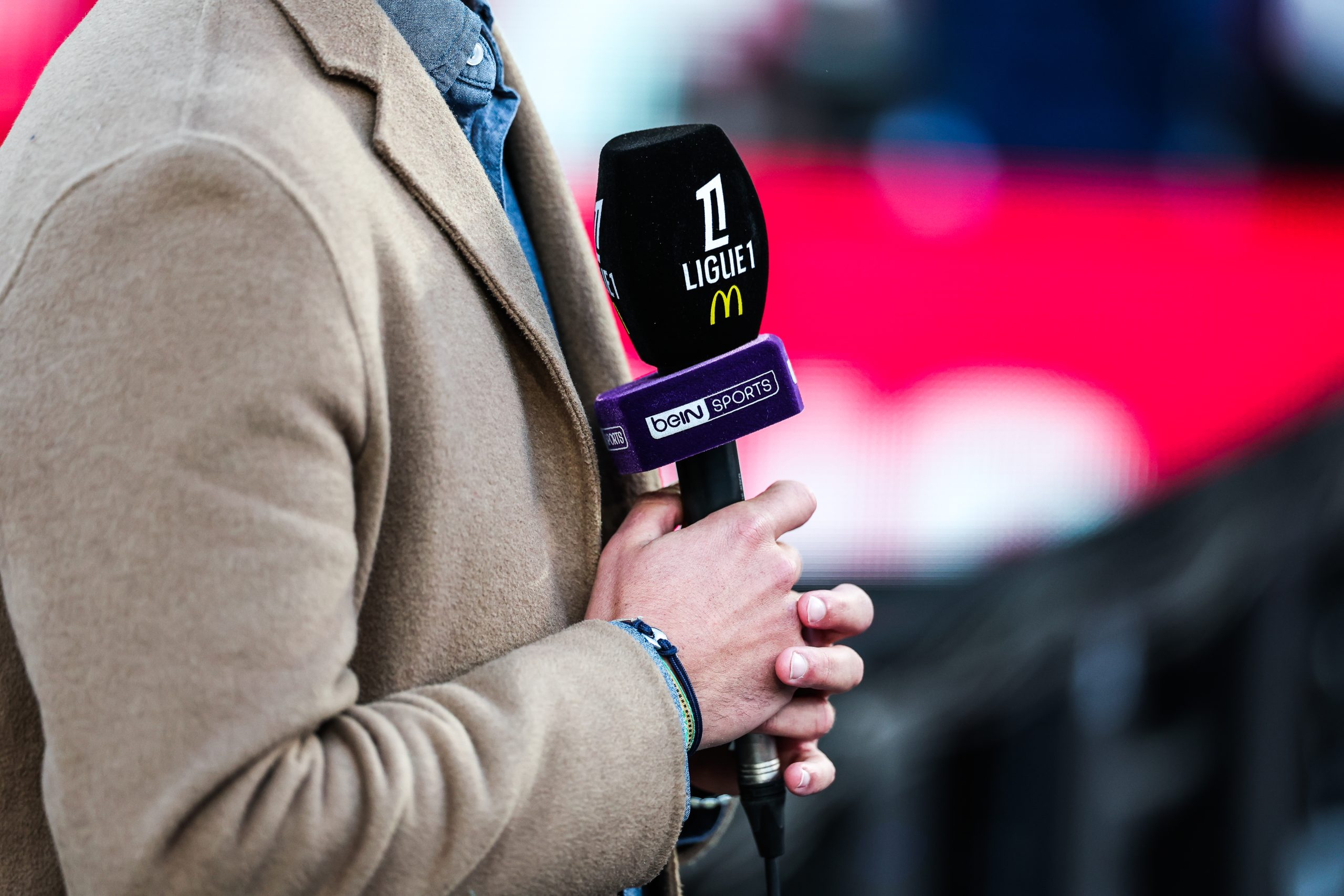 Un journaliste de beIN tenant un micro orné du nom de la chaîne.