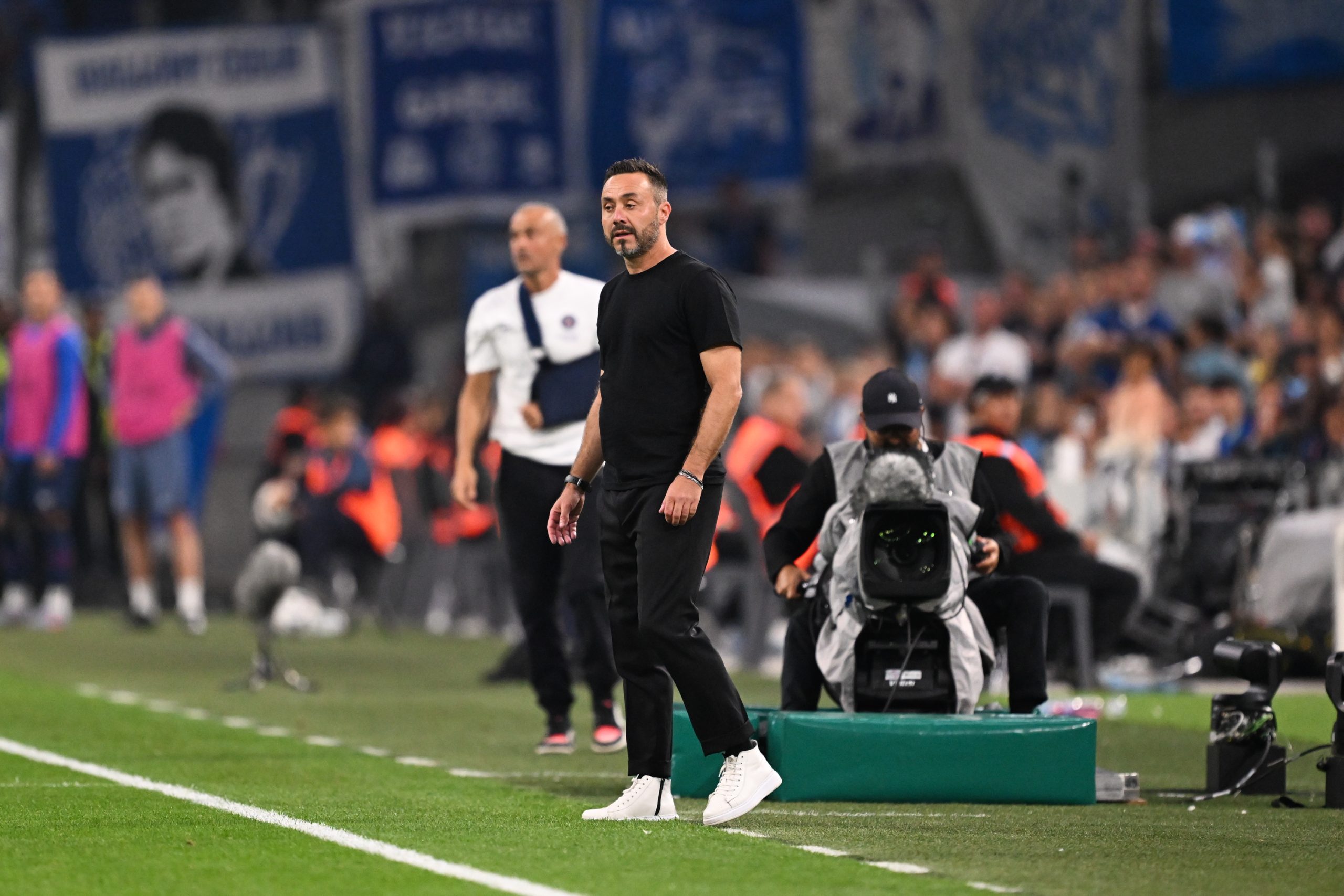 Roberto De Zerbi avec, en fond, un drapeau en hommage à Bernard Tapie.