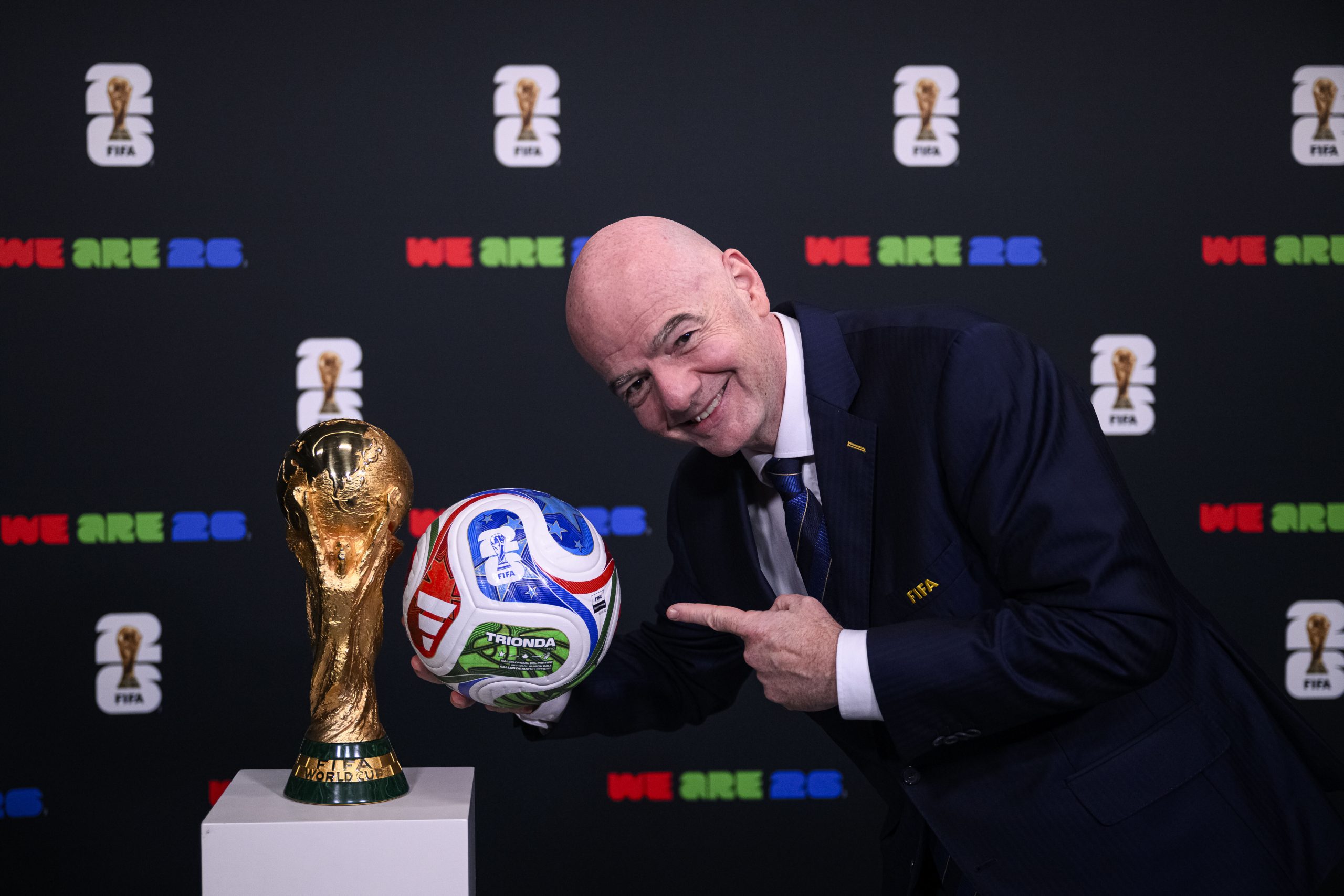 Le président de la FIFA, Gianni Infantino, posant avec le trophée de la Coupe du monde et le ballon de l'édition 2026.