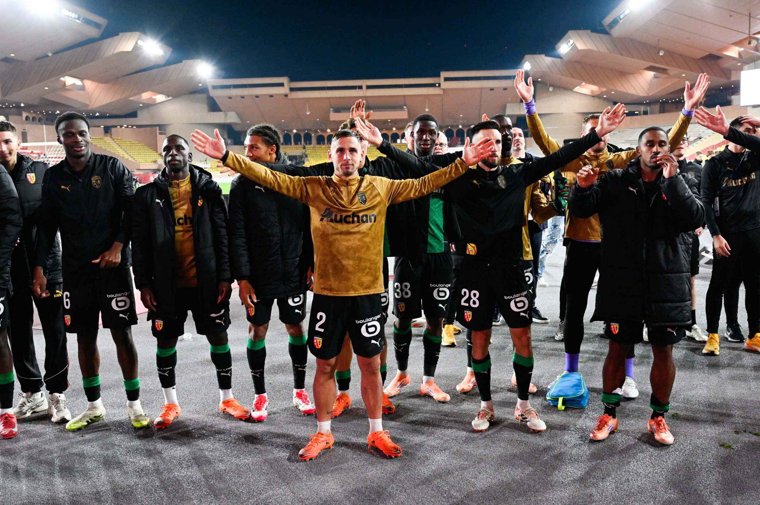 Les joueurs du RC Lens célébrant la victoire à Monaco avec leurs supporters.