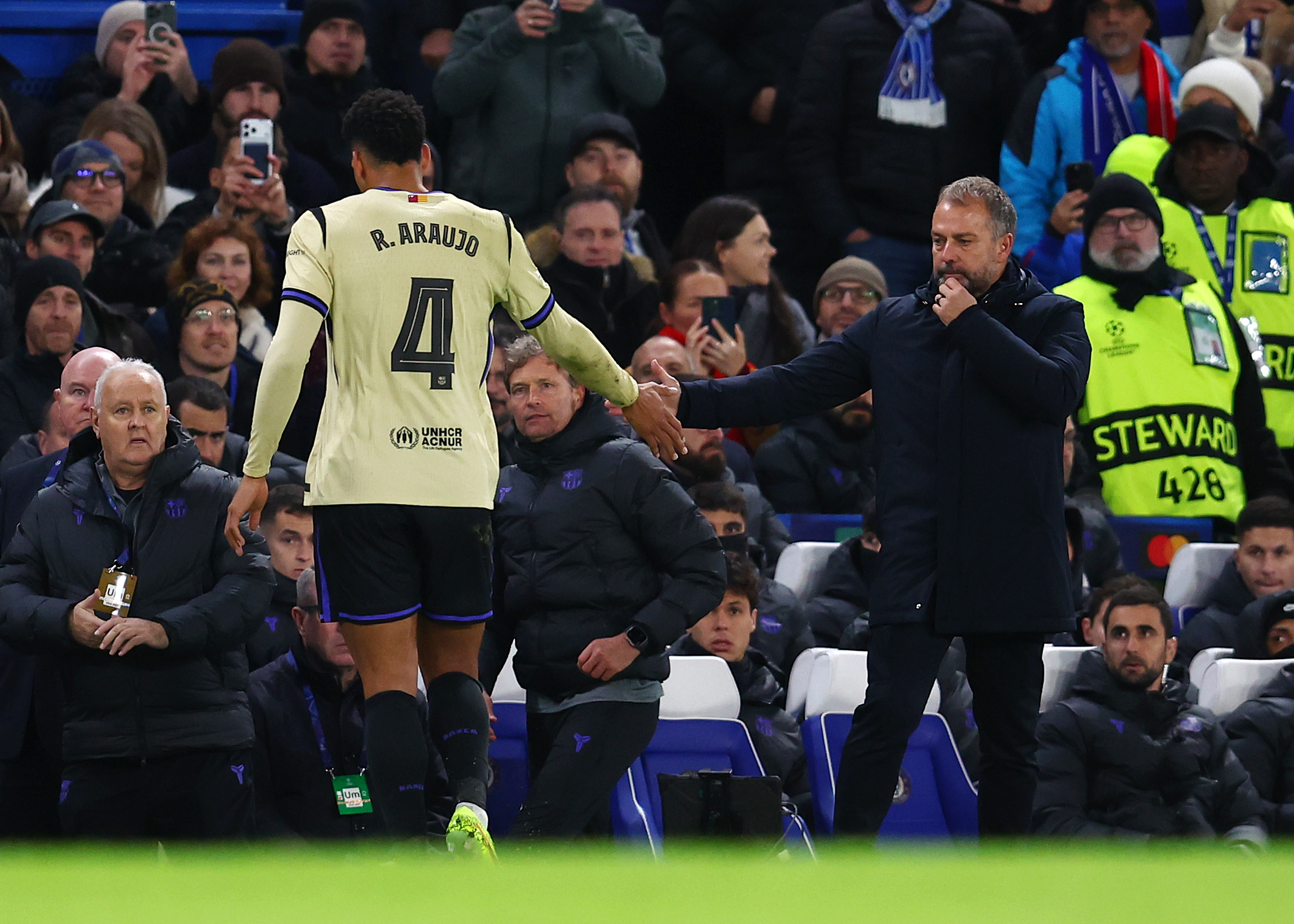 L'entraîneur du FC Barcelone, Hansi Flick, tapant dans la main de Ronald Araujo après son expulsion à Chelsea.