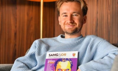 Bastien Kossek, supporter du RC Lens, qui pose avec le dernier numéro du magazine "Sang et Or".