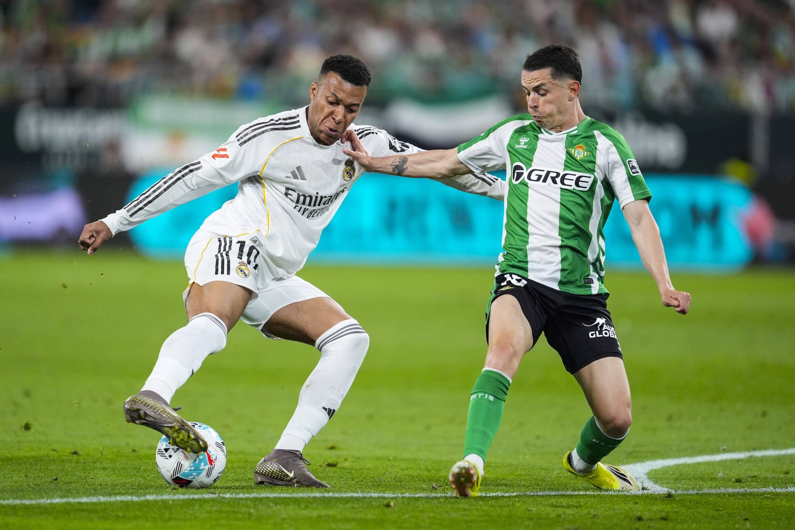 Kylian Mbappé tentant de dribbler un joueur du Betis Séville.