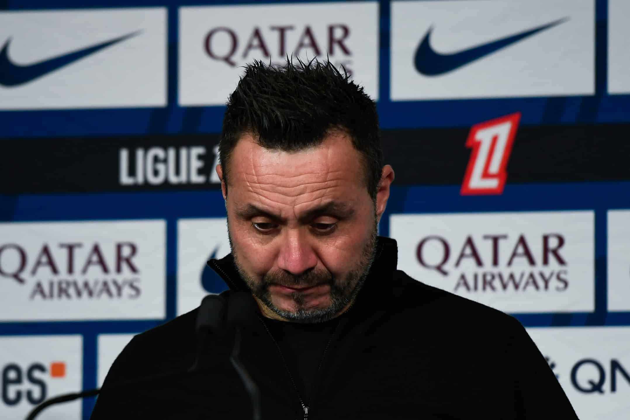 Roberto De Zerbi, regard baissé, lors de la conférence de presse ayant suivi la déroute à Paris.