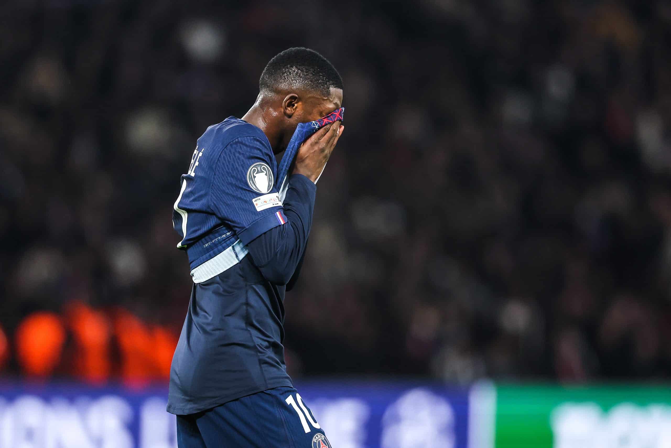 Ousmane Dembélé la tête dans son maillot après une action manquée.