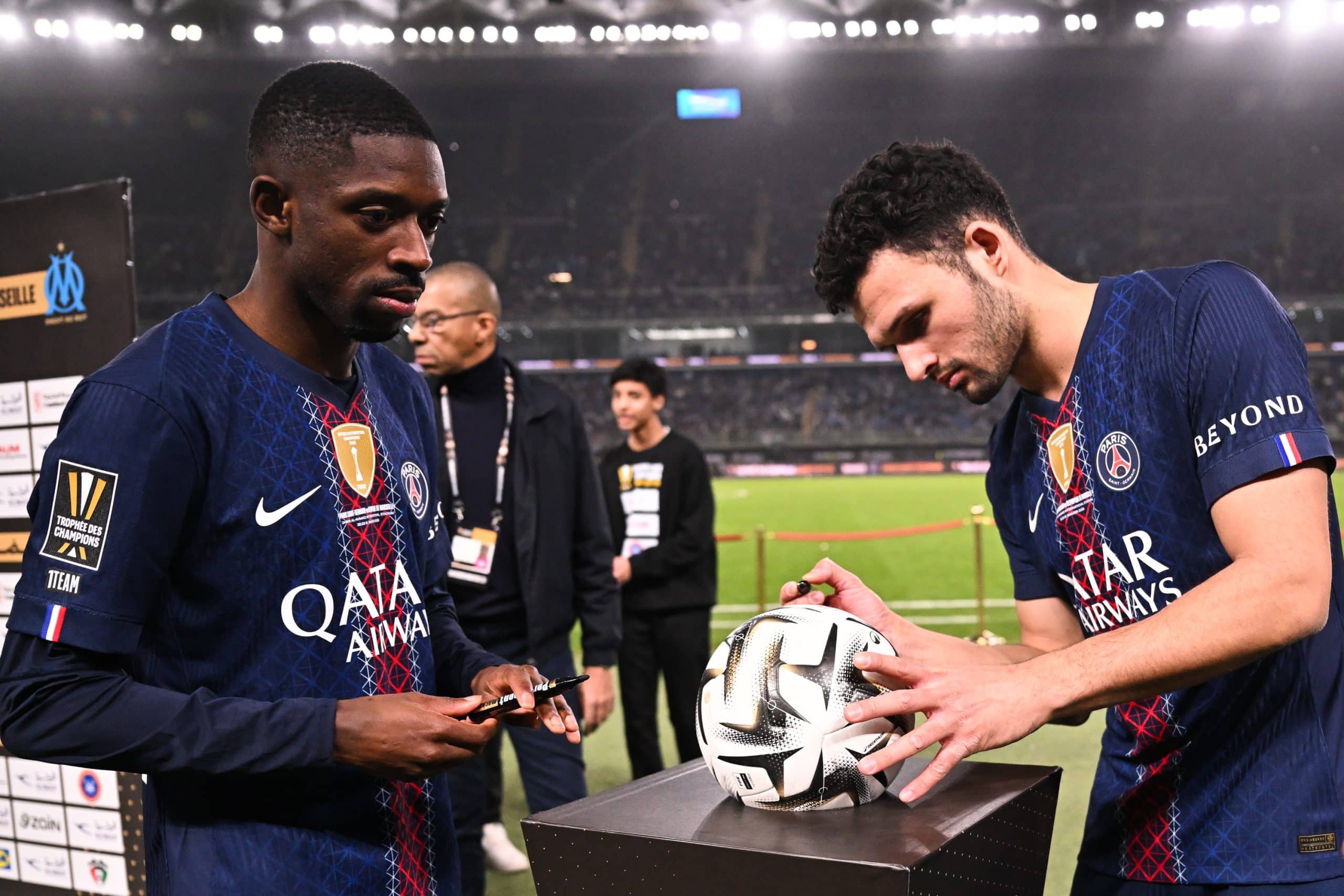 Ousmane Dembélé signant le ballon du match après le Trophée des champions.