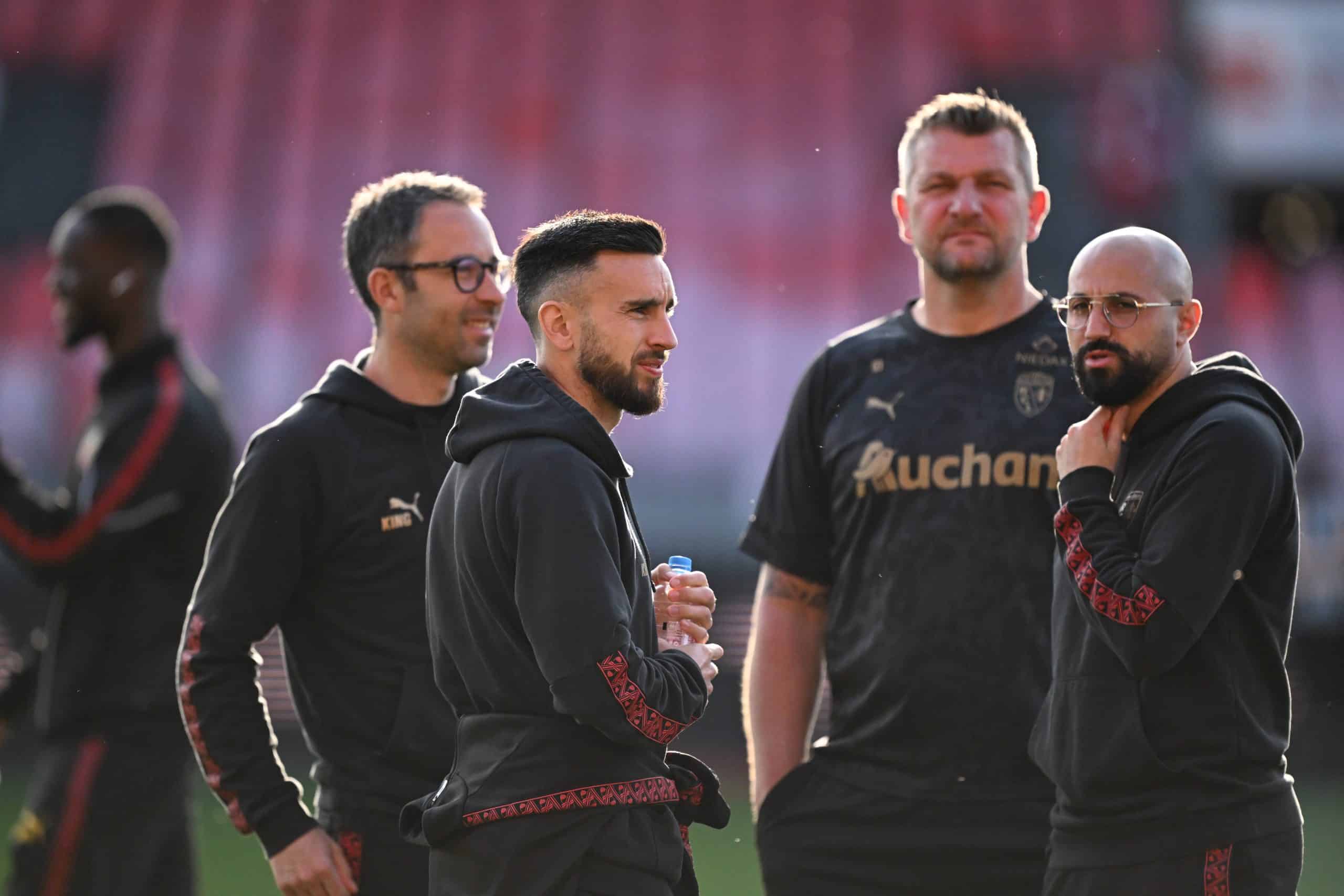 Adrien Thomasson discutant avec le staff technique du RC Lens.