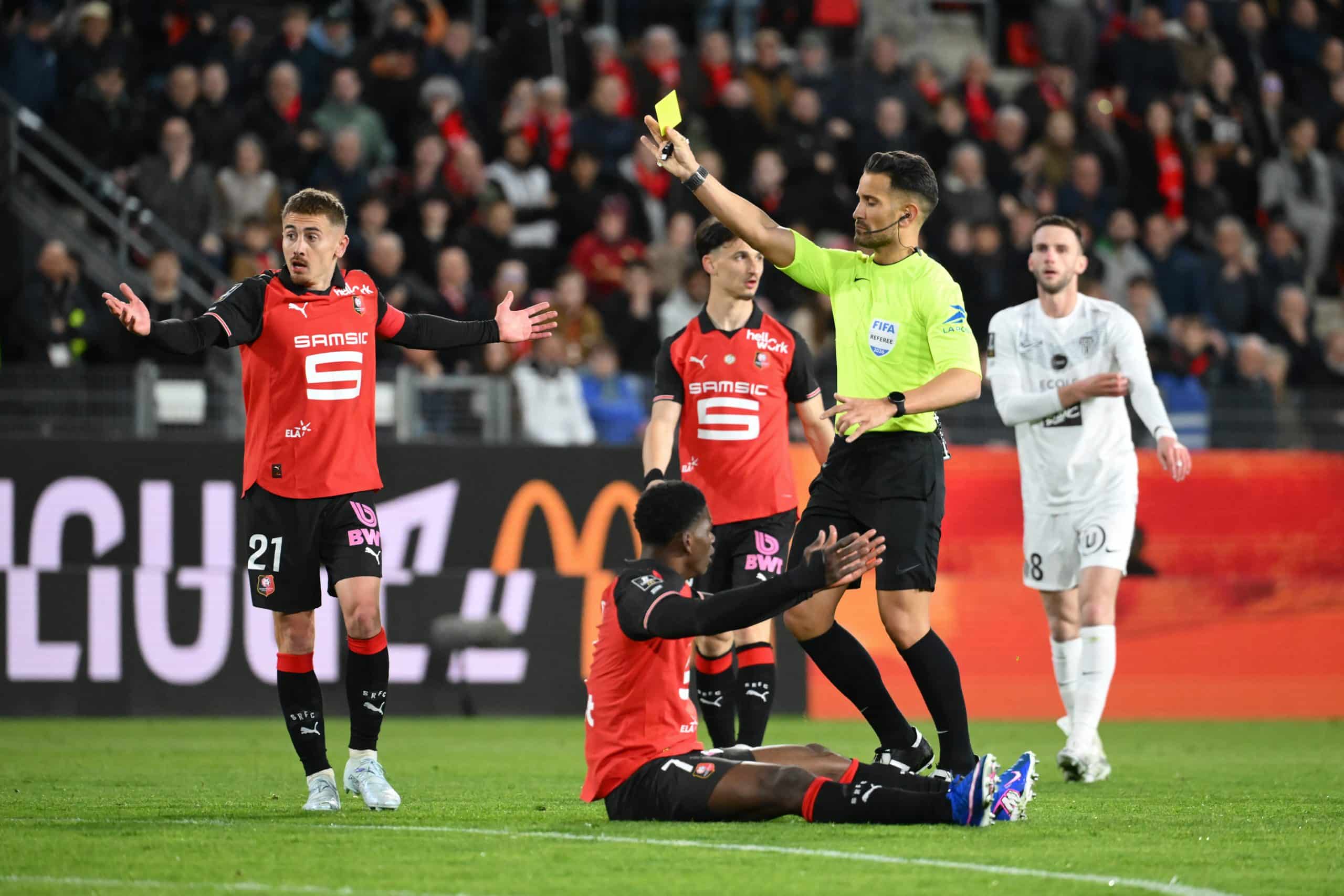 Mathieu Vernice brandissant un carton jaune lors du match Rennes-Angers.