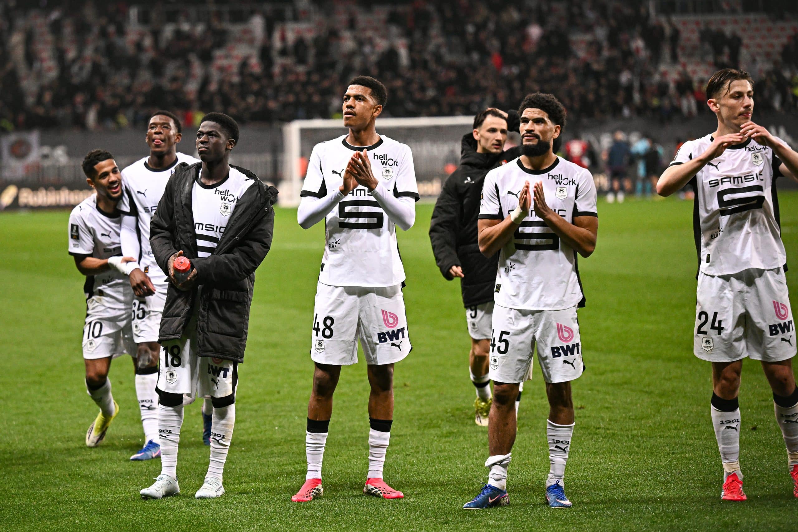 Abdelhamid Ait Boudlal au milieu de ses partenaires, applaudissant le public à la fin d'un match.